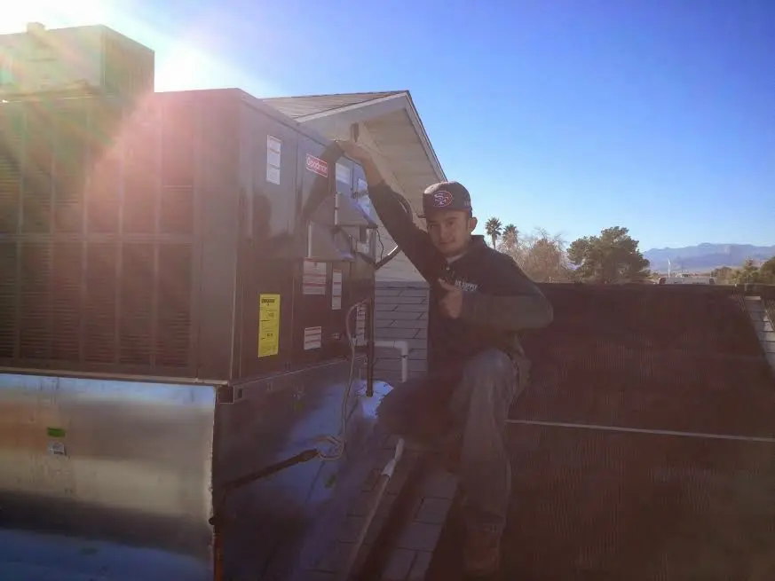 HVAC technician performing Air Duct Cleaning on a rooftop unit in Willow Springs